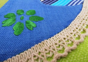 Chapim azul em tecido - pormenor da flor verde birdada na asa
