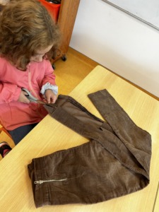 Criança a recortar tiras das calças de bombazine, para os troncos das árvores