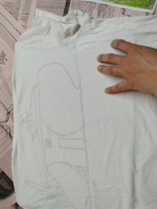 Desenho da casa na peça de vestuário usada, T-shirt branca.