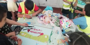 A foto mostra o painel em construção. Recorte de tecidos segundo os moldes, escolha de novos tecidos e criatividade no painel.