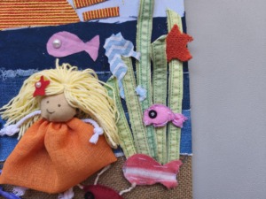 Detalhe  da capa recriada: a menina do mar surge entre peixes e algas, num mar de texturas e cores feito com materiais e tecidos reutilizados.