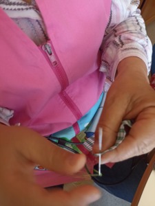 Colaboração das educadoras a cozer o tecido.